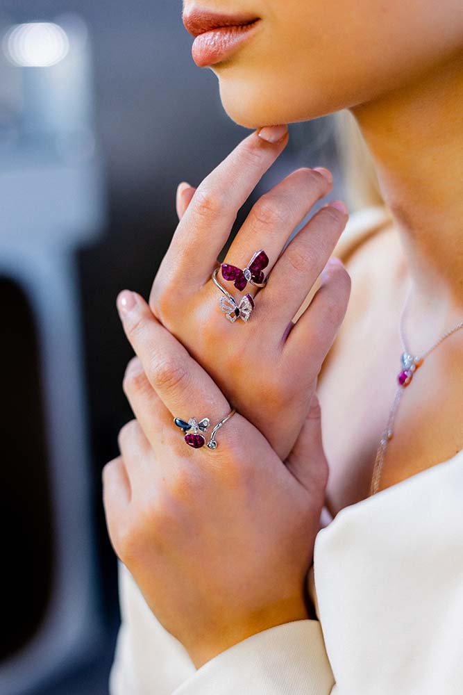 In einem Juweliergeschäft zeigt eine Nahaufnahme die Hand eines Mädchens, die einen atemberaubenden und wertvollen Ring aus Diamanten und Gold zeigt.